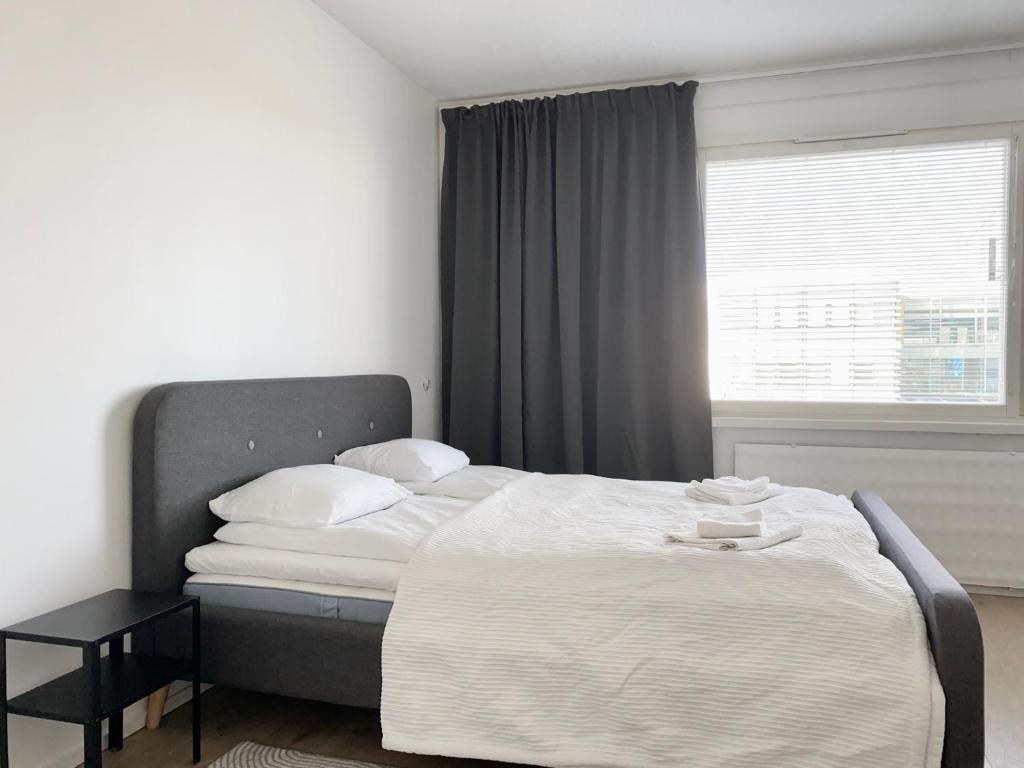 a bedroom with a large bed with a window at Travel Center Studio in Pori