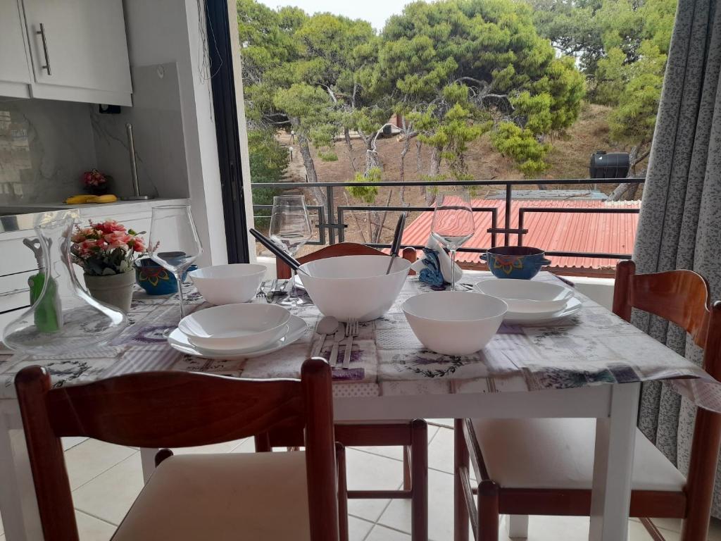 a dining room table with bowls and plates on it at Heraklion Centre Experiene in Heraklio