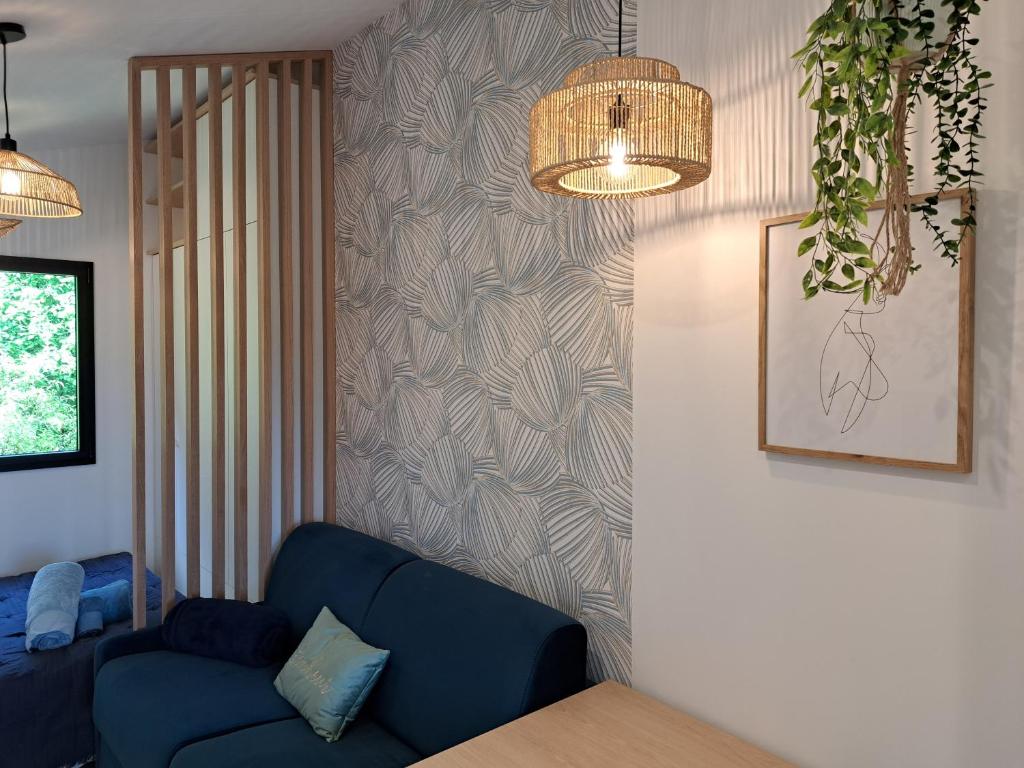 a living room with a blue couch and a wall at Les terrasses de Condate - Rennes canal St Martin in Rennes