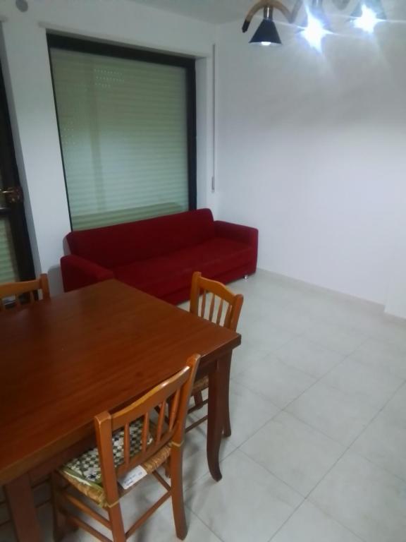 sala de estar con mesa y sofá rojo en Casa Materdomini, en Brindisi