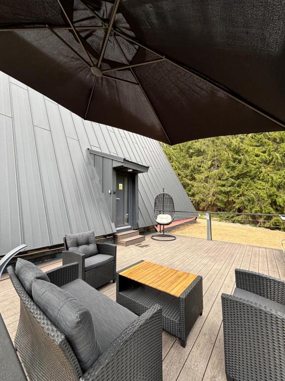 a patio with chairs and a table and an umbrella at Tramonto Cabin in Vartop