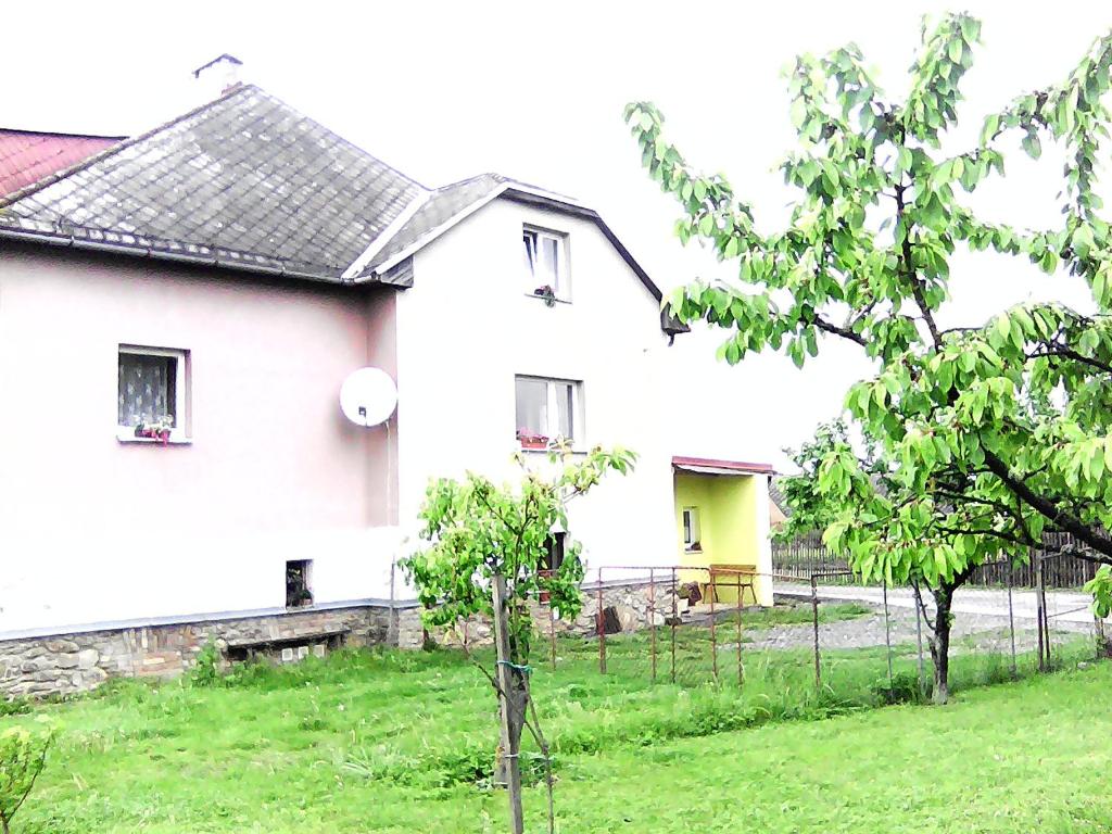 een wit huis met een gele deur in een tuin bij Ubytování v soukromí - Vila Eliška in Světlá nad Sázavou