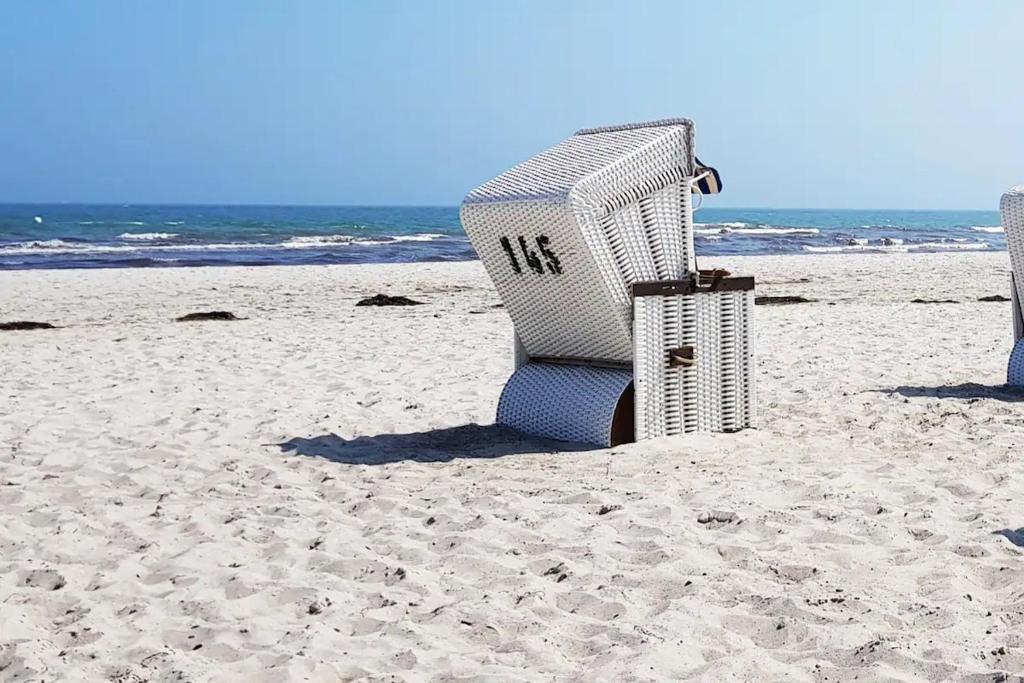 a beach chair sitting on the sand on the beach at Ostseeliebe - Sünnenkieker WE7, Beckerwitz in Beckerwitz