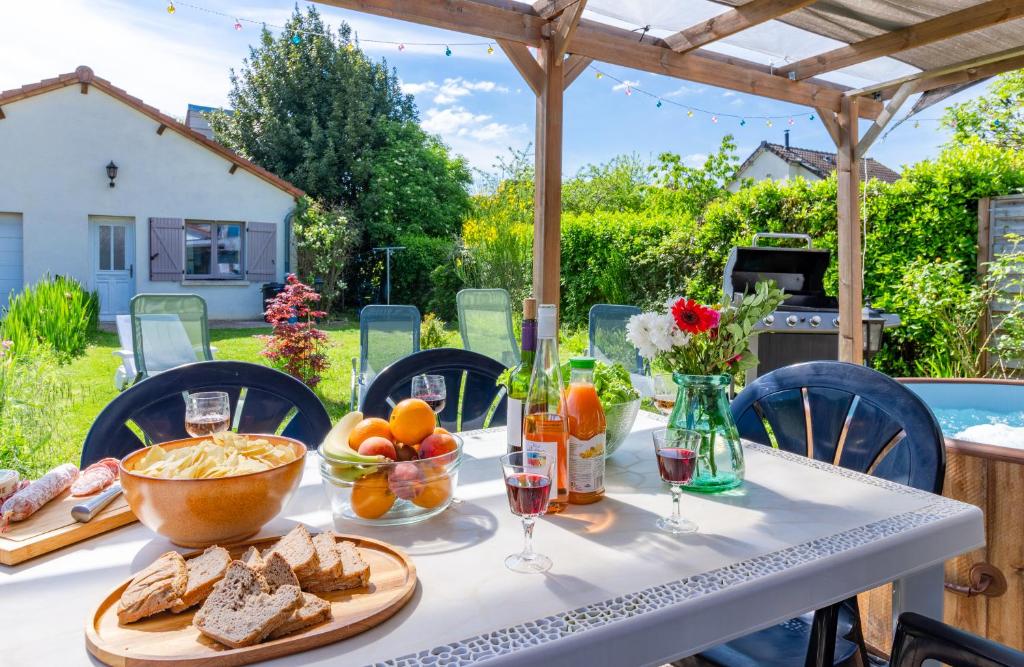 - une table avec du pain, des fruits et des verres à vin dans l'établissement La joie de vivre: logement entier, parking privé, à Sainte-Savine