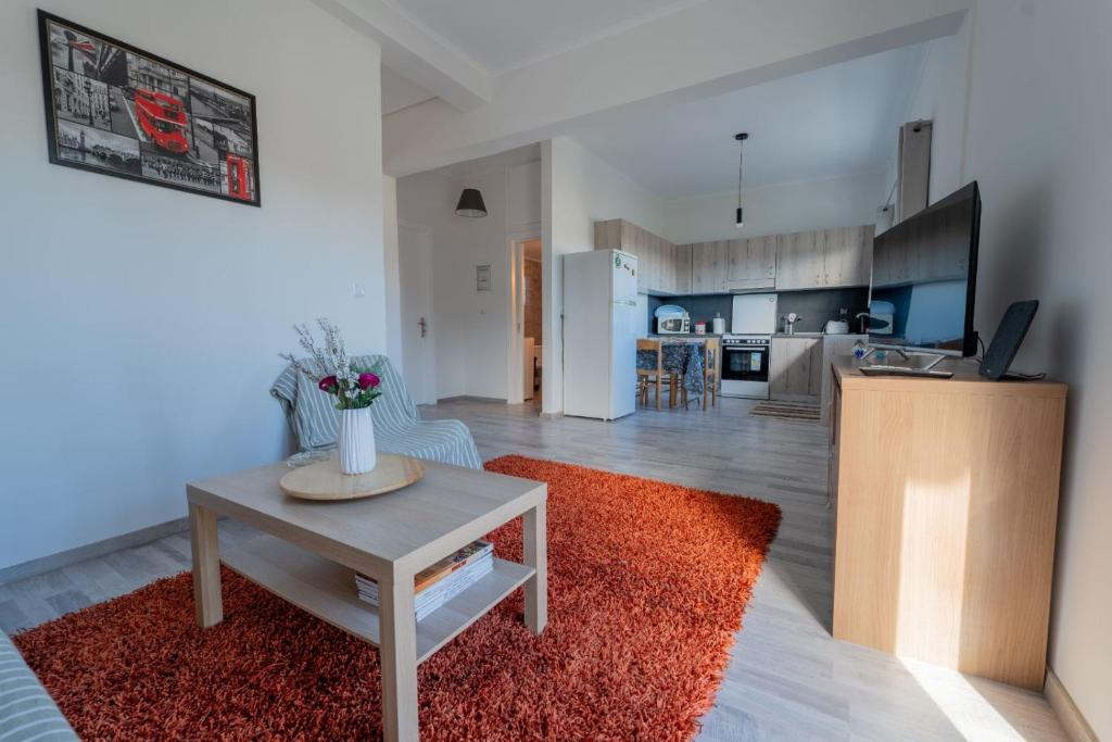 a living room with a table and a kitchen at Anastasia's lemon garden in Artemida