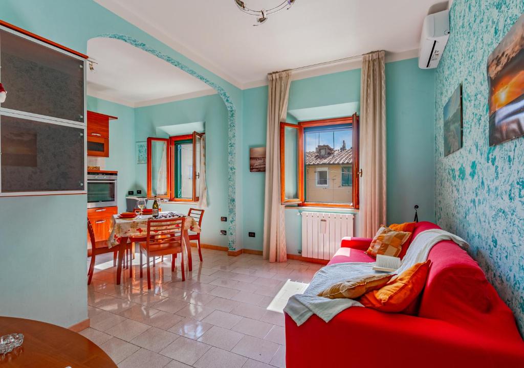 uma sala de estar com um sofá vermelho e uma mesa em Casa Kira em Livorno