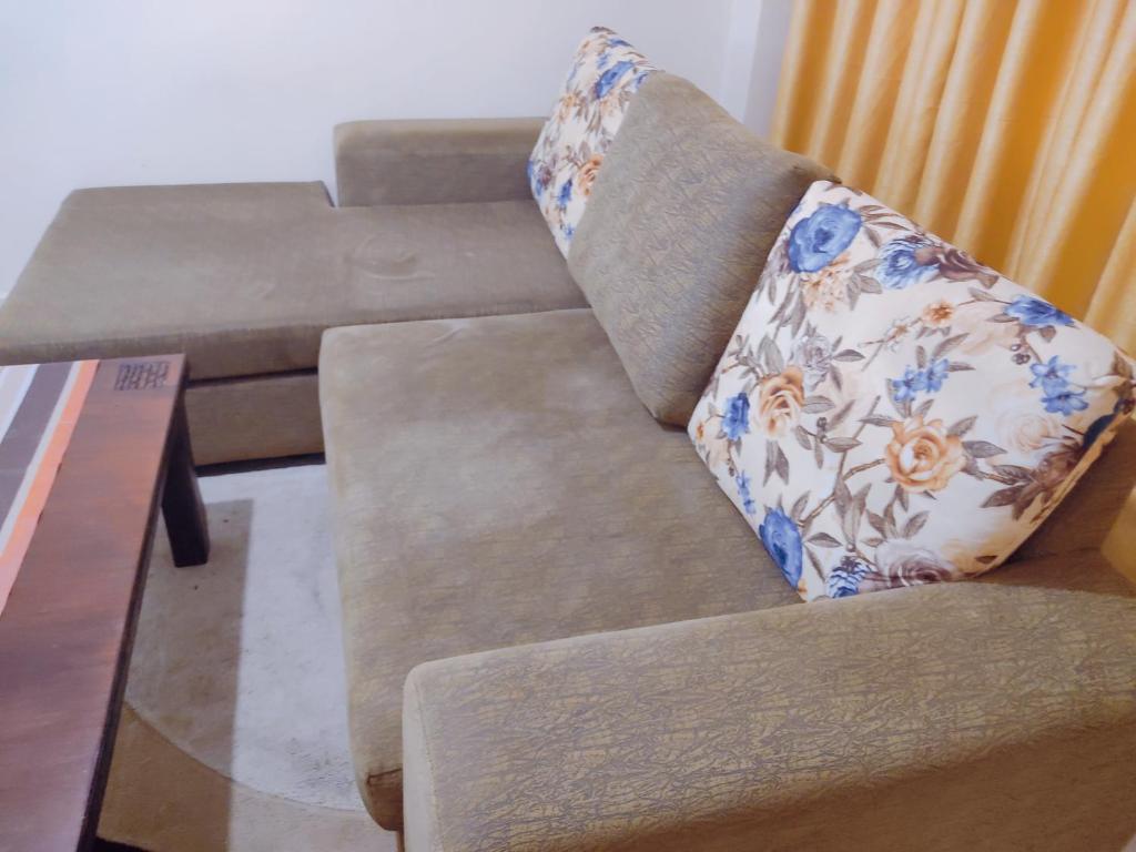 un sofá con una almohada junto a una mesa en Crystal homes, en Nairobi