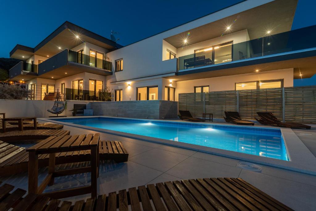 una casa con piscina frente a ella en Villa Helena en Trogir