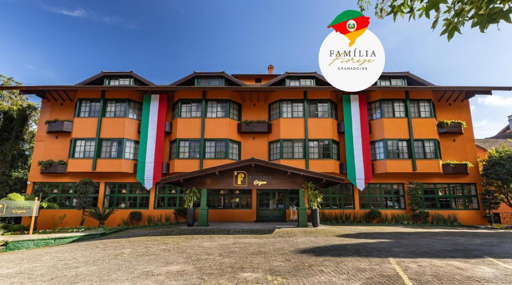 an orange hotel with a sign on the front of it at Hotel Fioreze Origem in Gramado