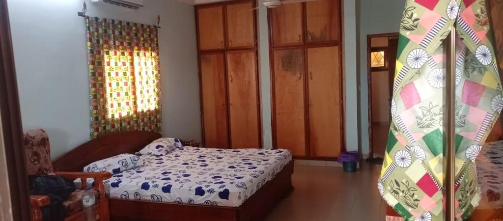 ein kleines Schlafzimmer mit einem Bett und einem Fenster in der Unterkunft Résidence la Grâce Benkadi in Bobo-Dioulasso