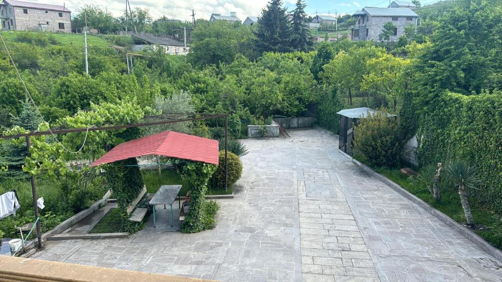 a garden with a bench and an umbrella at Nice House in Ijevan