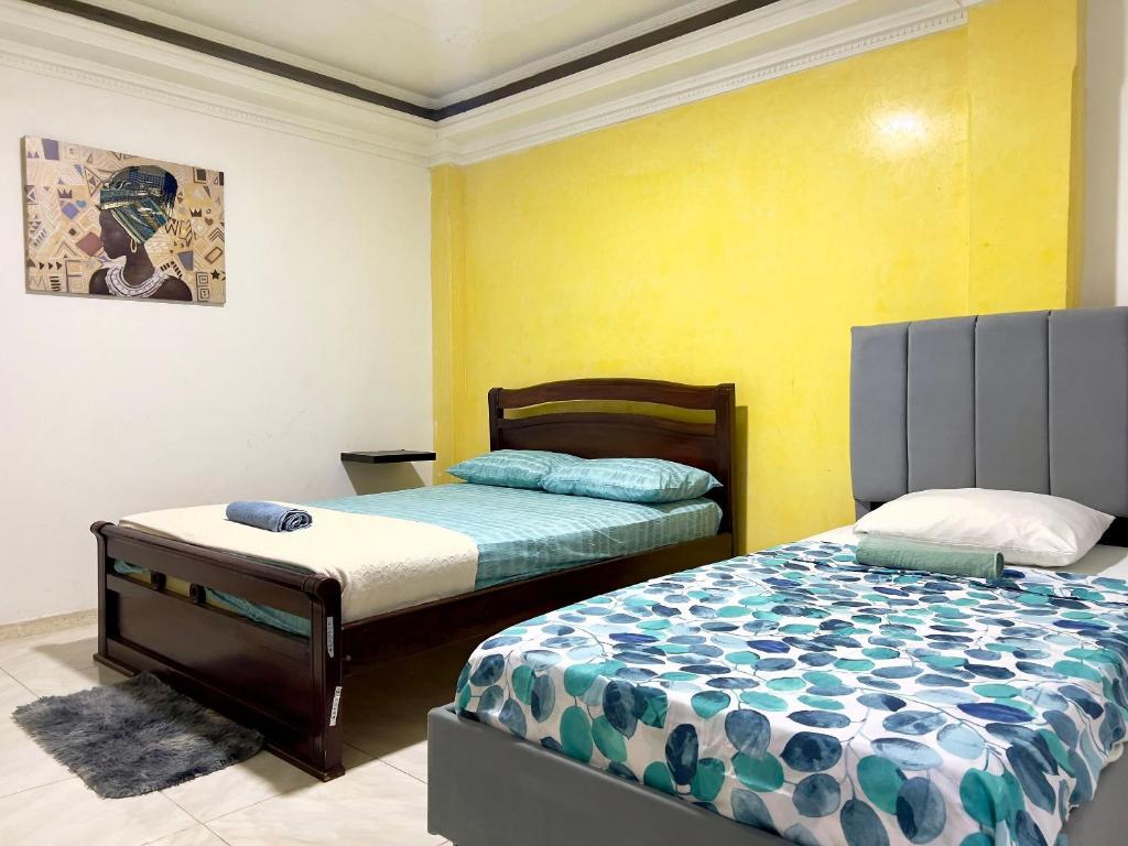 a bedroom with two beds and a yellow wall at Apartamento Cerca al Complejo Deportivo in Valledupar