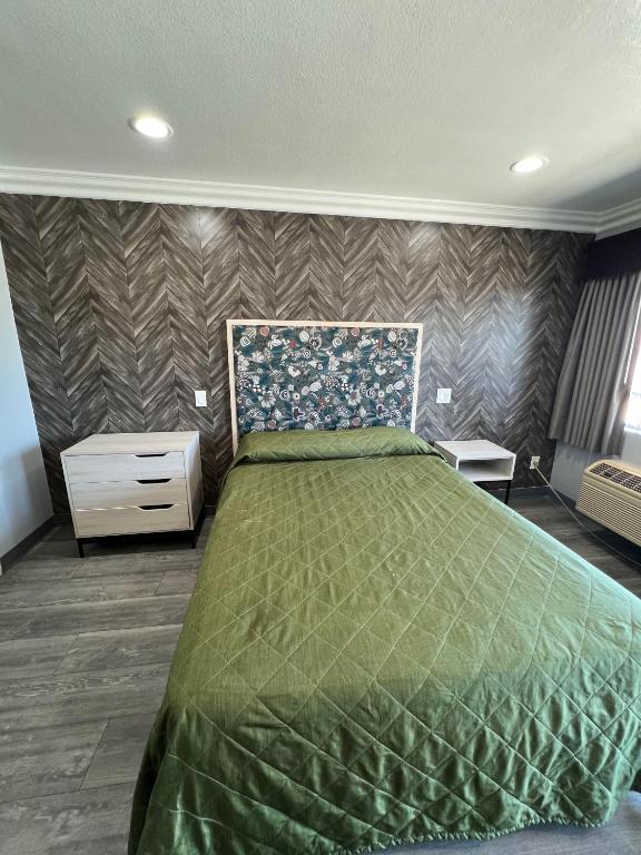 a bedroom with a bed with a green bedspread at Harbor Inn in Harbor City