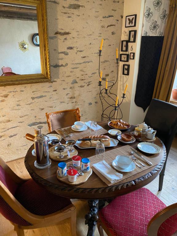 a wooden table with food on top of it at Une nuit chez une artisane in Josselin