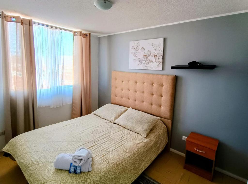 a bedroom with a bed with a stuffed animal on it at Departamento equipado 348 Ovalle in Ovalle
