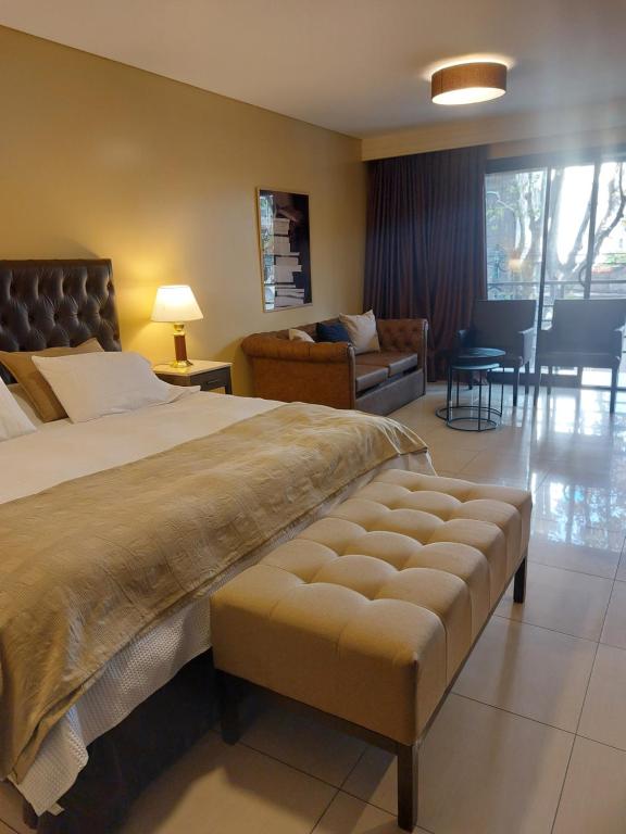 a bedroom with a large bed and a living room at Comfortable Modern Apartment in Buenos Aires