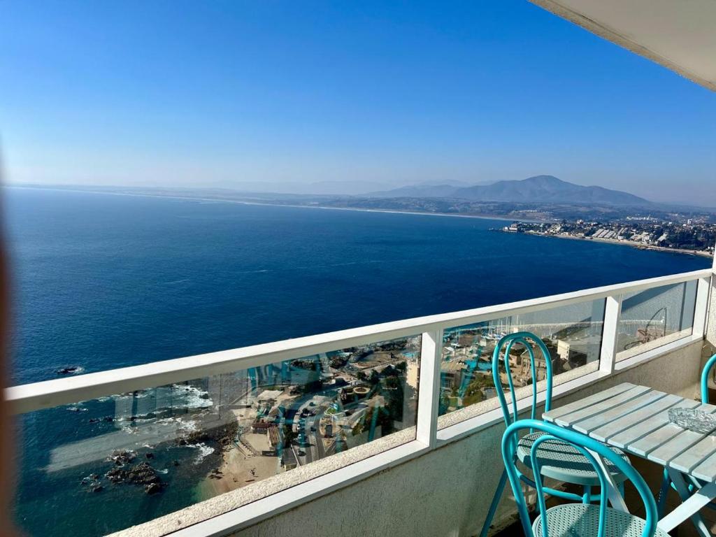 Un balcón con mesa y sillas y el mar. en VISTAMAR COSTAHORIZONTE CONCON, en Concón