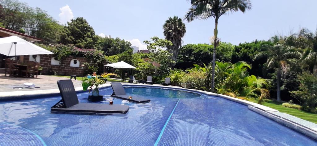 a swimming pool with two lounge chairs and an umbrella at Cuernavaca Eden Hotel Boutique doble in Cuernavaca