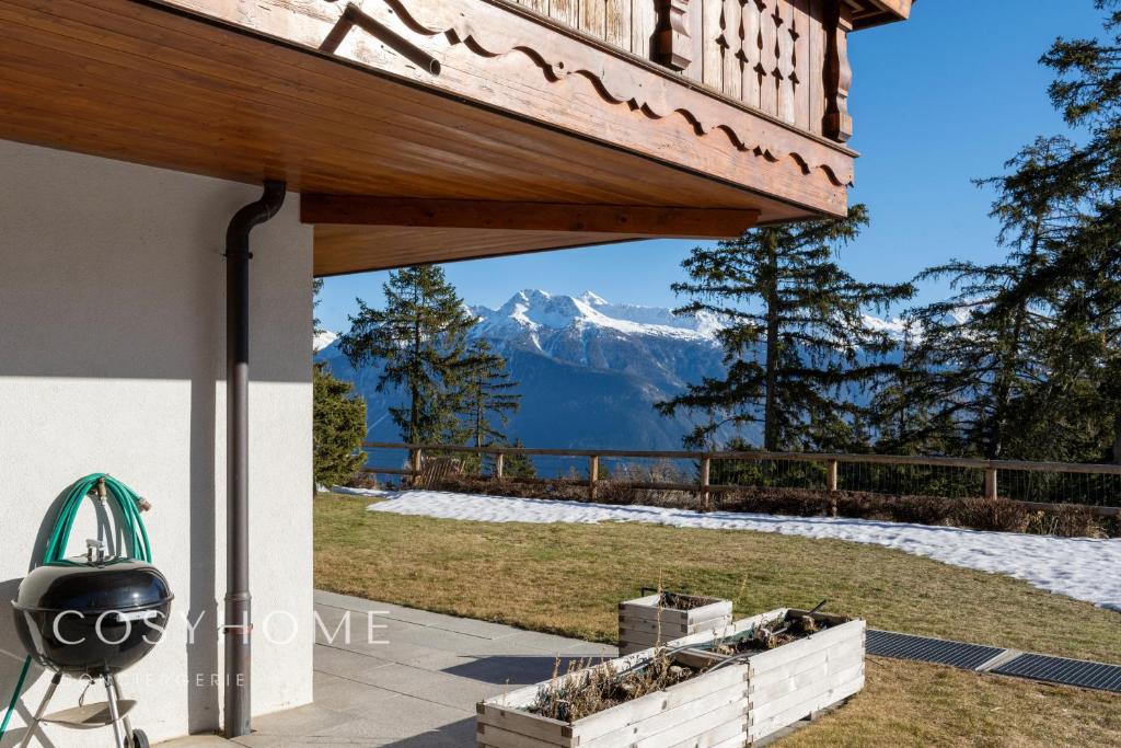 a patio with a view of a mountain at Le Saint Georges l Jardin et vue in Crans-Montana