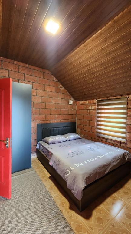 Un dormitorio con una cama grande en una pared de ladrillo. en Sevan - Lavanda Cottages, en Sevan