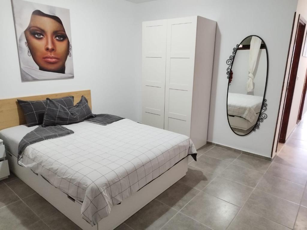 a bedroom with a bed and a mirror at Apartment mit schöner Aussicht und Balkon in San Marcos