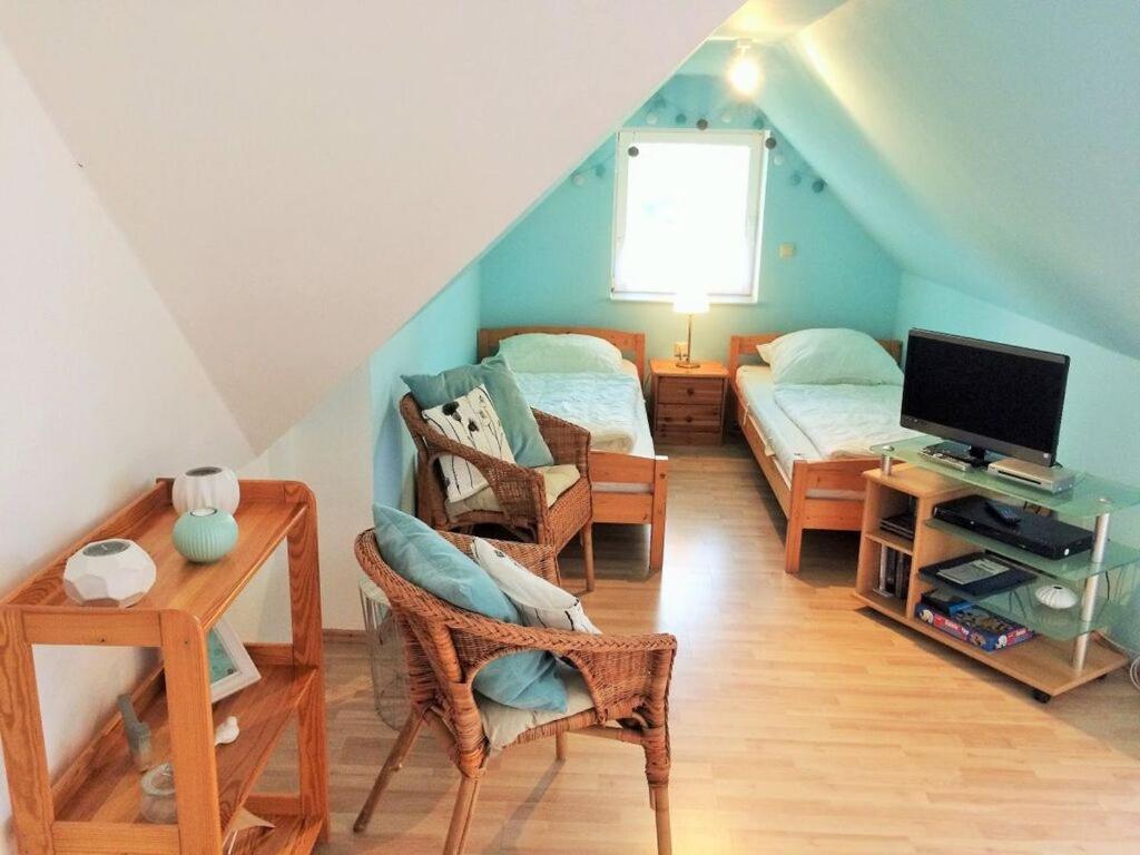 een zolderkamer met 2 bedden en een televisie bij Pleasant apartment in Insel Poel in Insel Poel