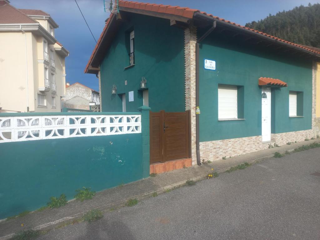 ein blaues Haus mit einer Holztür auf einer Straße in der Unterkunft Casa Pepe El Segador - VV-1054-AS in San Juan de la Arena