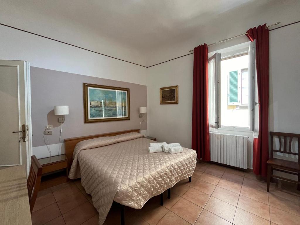 a bedroom with a bed and a window at Althea Rooms in Florence