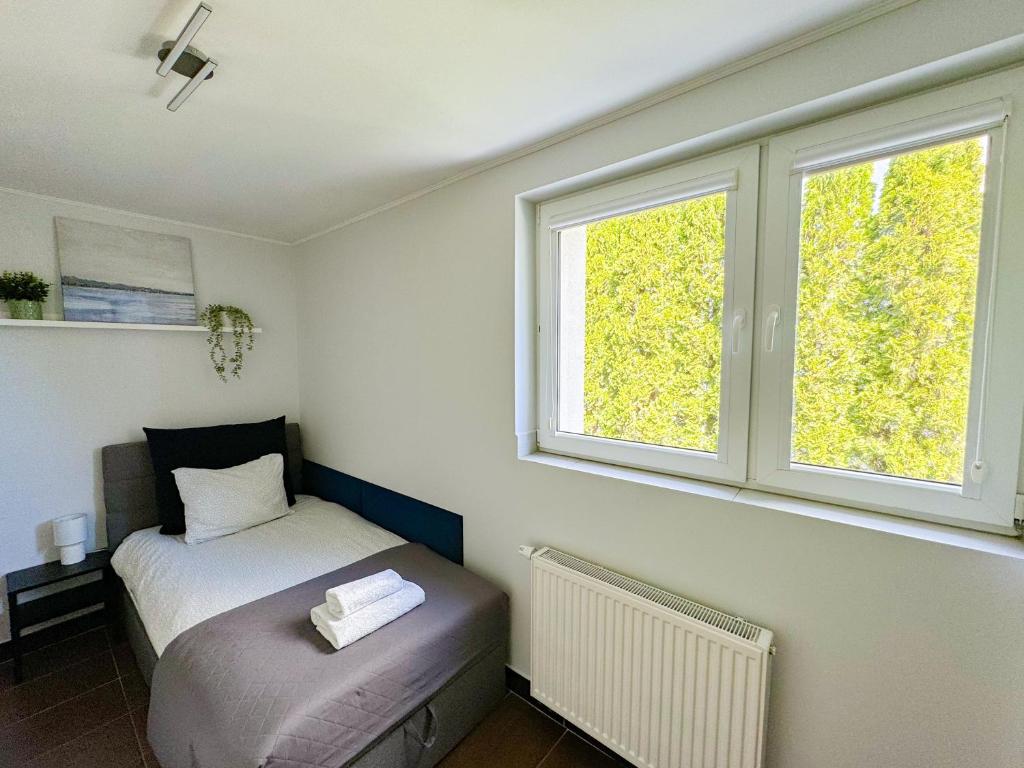 um pequeno quarto com uma cama e uma janela em Pokoje Gościnne Przy Molo em Gdynia