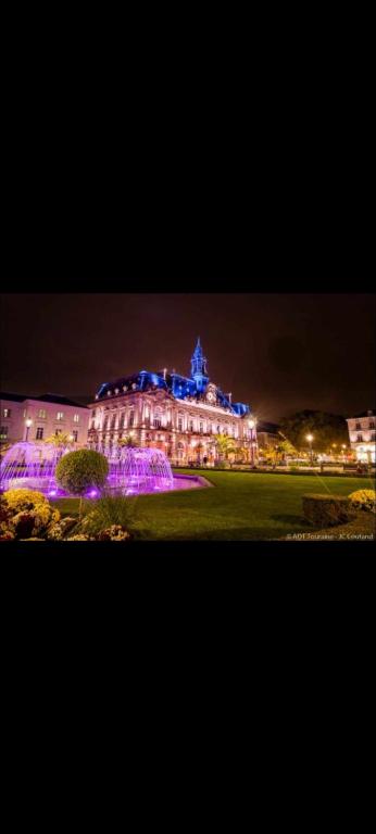 un grand bâtiment avec des lumières allumées la nuit dans l'établissement T3 centre-ville avec parking, à Tours