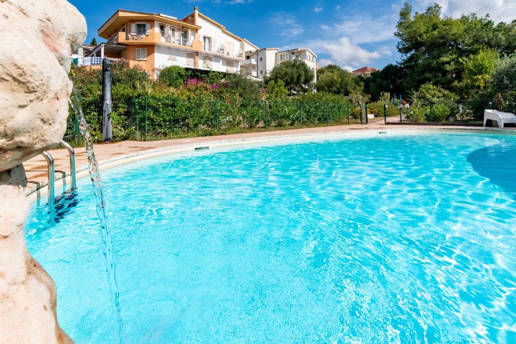 una gran piscina con un edificio en el fondo en Villa Agnese, en Badesi