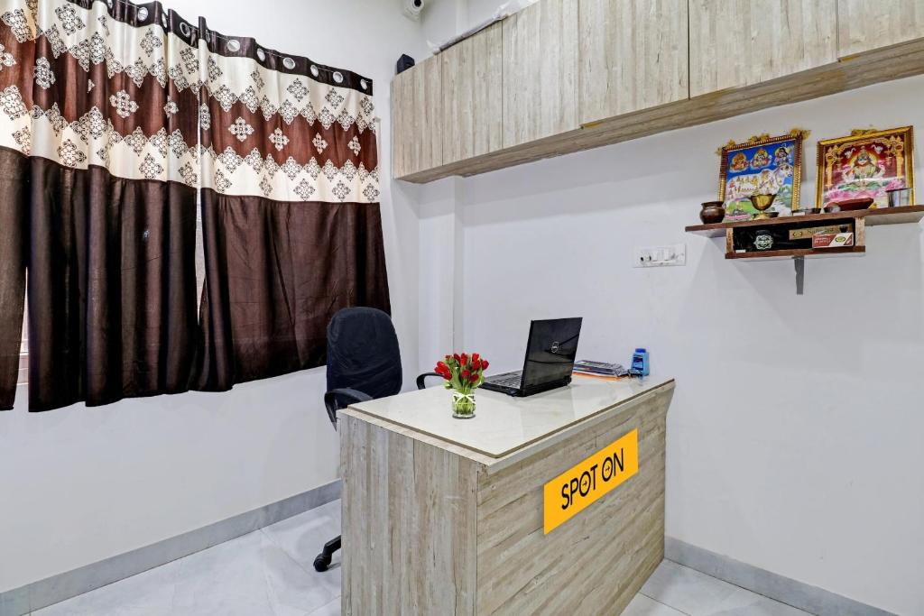 una oficina con un escritorio con un cartel. en OYO Zois Nest, en Kammasandra