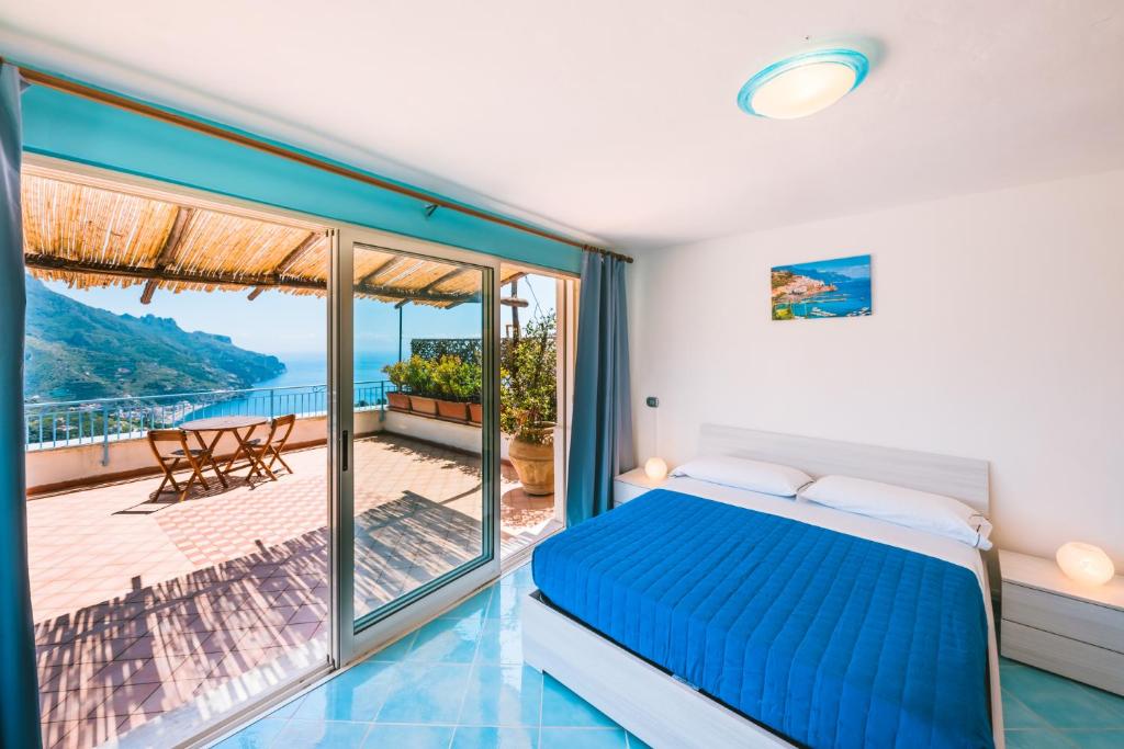 ein Schlafzimmer mit einem Bett und einem Balkon in der Unterkunft Sea view - Ravello houses in Ravello