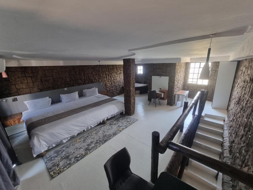 sypialnia z dużym łóżkiem i schodami w obiekcie Rustiek Hotel w mieście Kasane