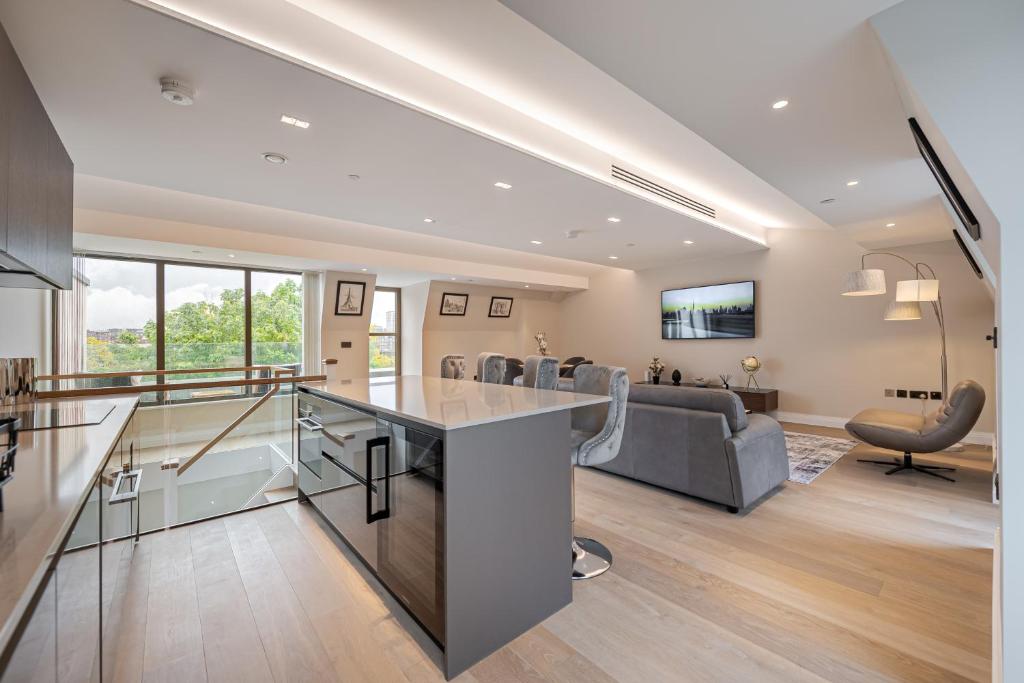 cocina abierta y sala de estar con sofá en Arcadia Residences - Luxury Apartments in Kensington en Londres