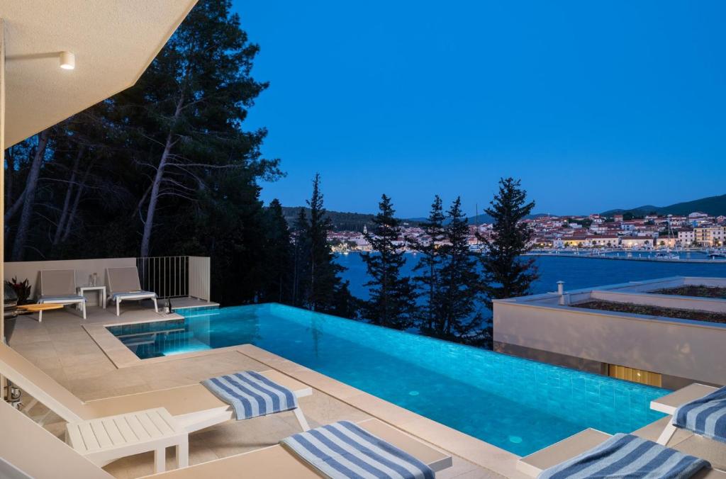 een villa met een zwembad en een patio bij Luxury & stylish Villa Maslina 10 m from the sea in Vela Luka