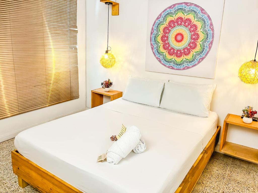 1 dormitorio con 1 cama blanca grande y 2 mesas en Hostal Casa Guadalupe en Medellín