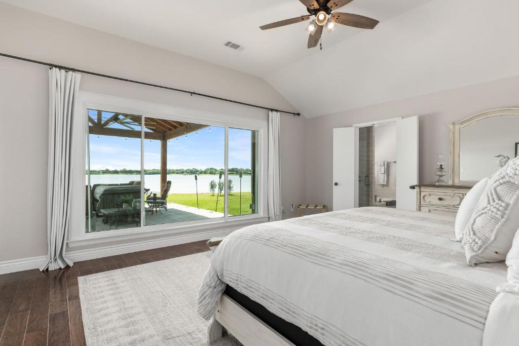 1 dormitorio con cama y ventana grande en Lakefront Family Vacation Home close to Frisco and Dallas, en Little Elm