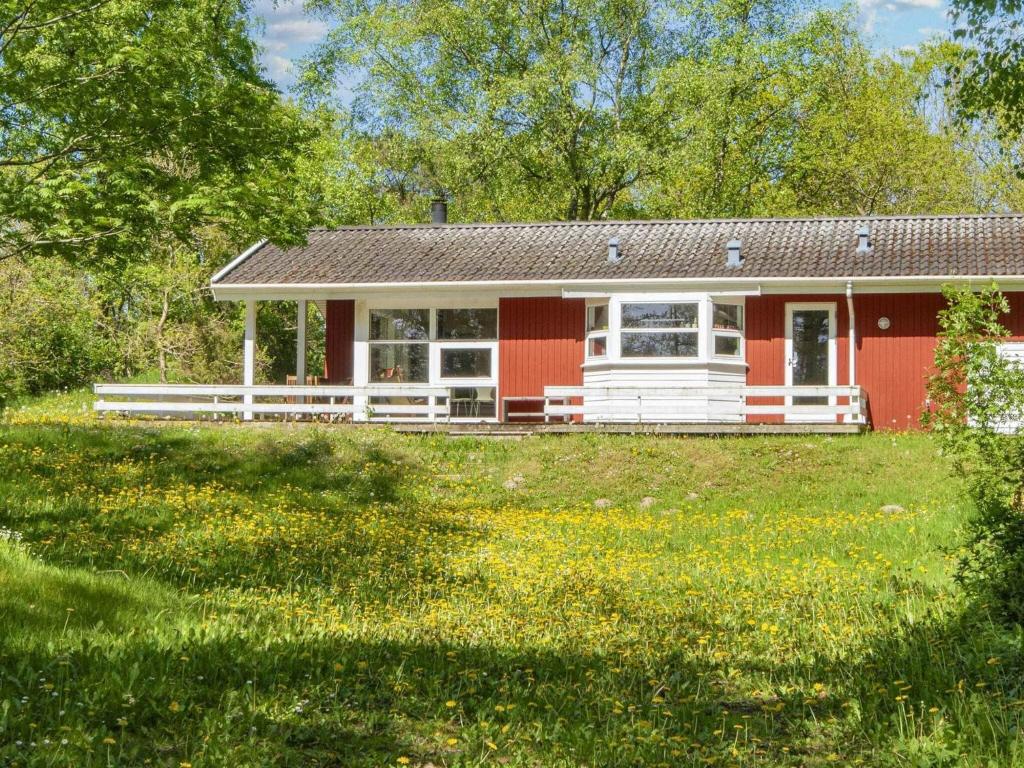 a red and white house in a field of flowers at 8 person holiday home in Glesborg in Glesborg