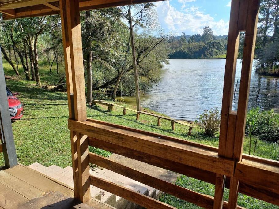 a view of a lake from the porch of a cabin at Cabana de pesca e lazer Represa Usina Mafra sc in Mafra