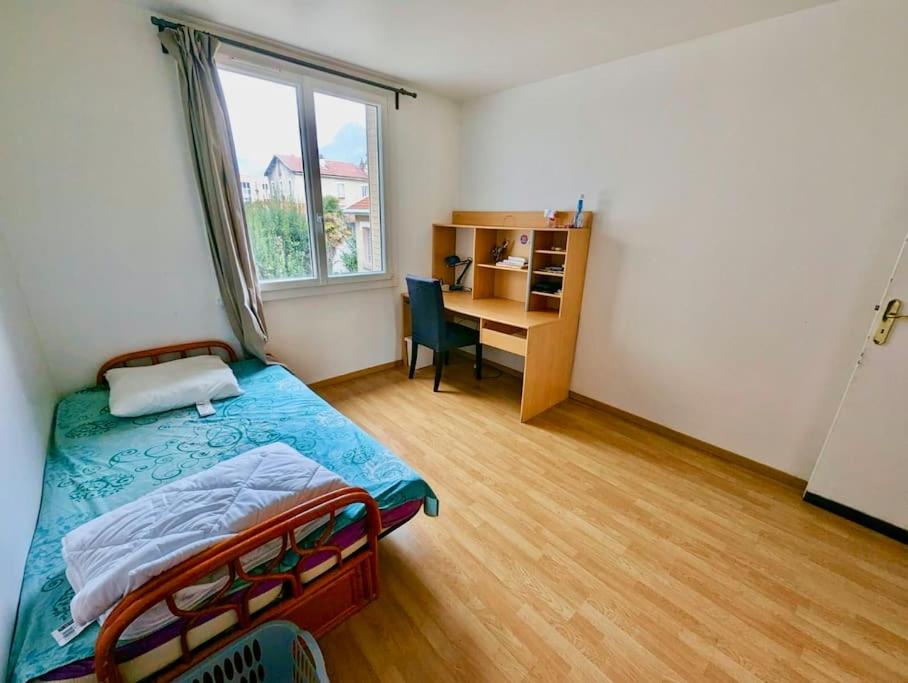 une chambre avec un lit et un bureau avec une fenêtre dans l'établissement Sublime Chambre - Equipée & Wifi, à Grenoble
