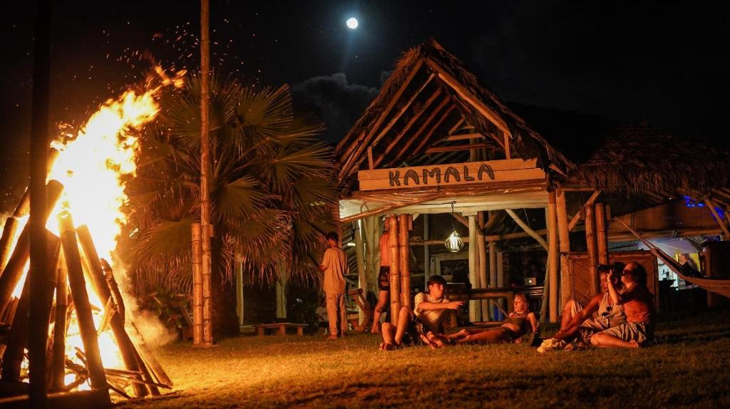 a group of people sitting in front of a fire at Kamala Surf & Backpacker Hostel in Montañita