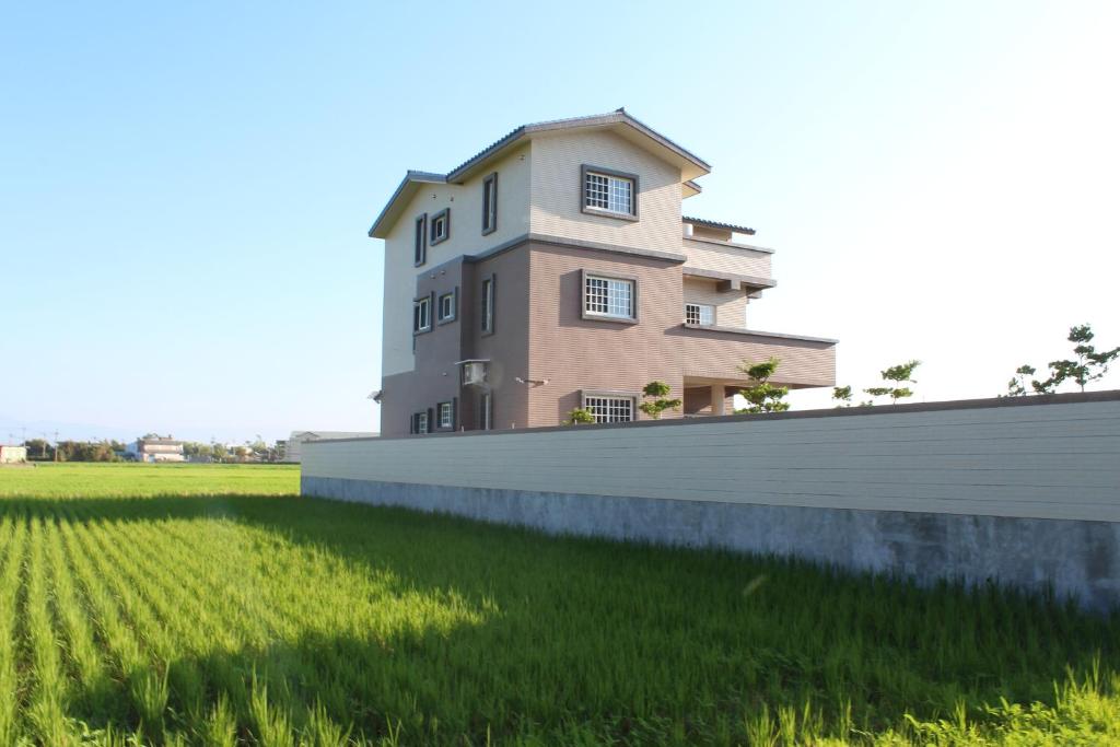 a house in a field next to a fence at Lefu B&B in Dongshan