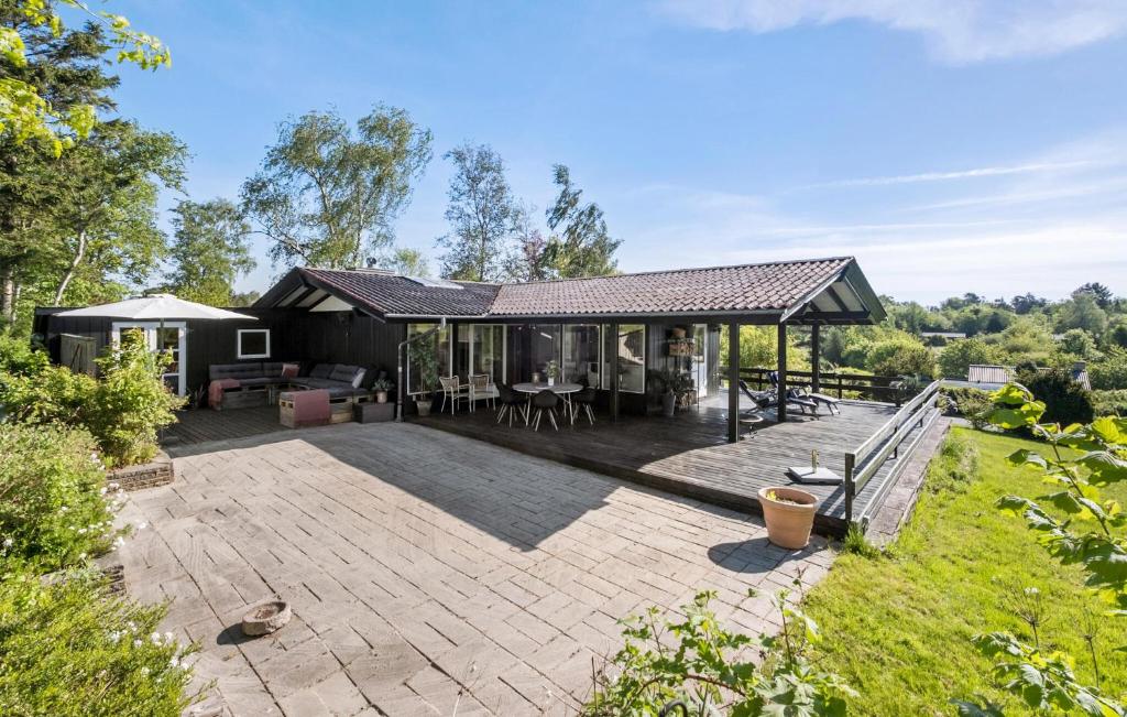 ein Haus mit einer großen Terrasse im Hinterhof in der Unterkunft 3 Bedroom Gorgeous Home In Vejby in Vejby