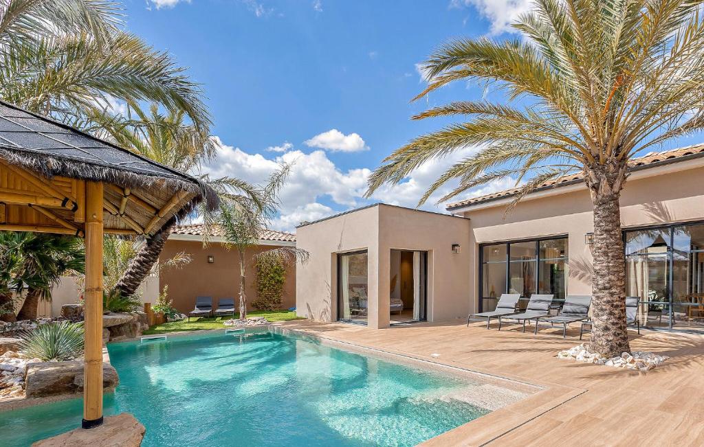 une villa avec piscine et palmiers dans l'établissement Ruben, à Puimisson
