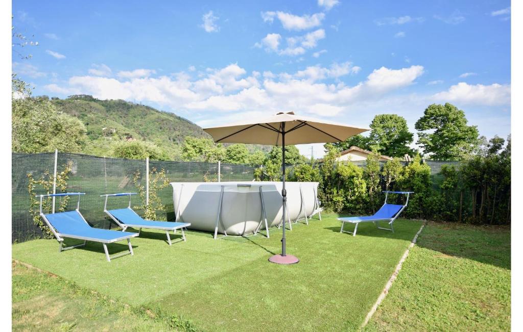 a table and two chairs and an umbrella on the grass at 3 Bedroom Cozy Home In Piano Di Mommio in Piano di Mommio