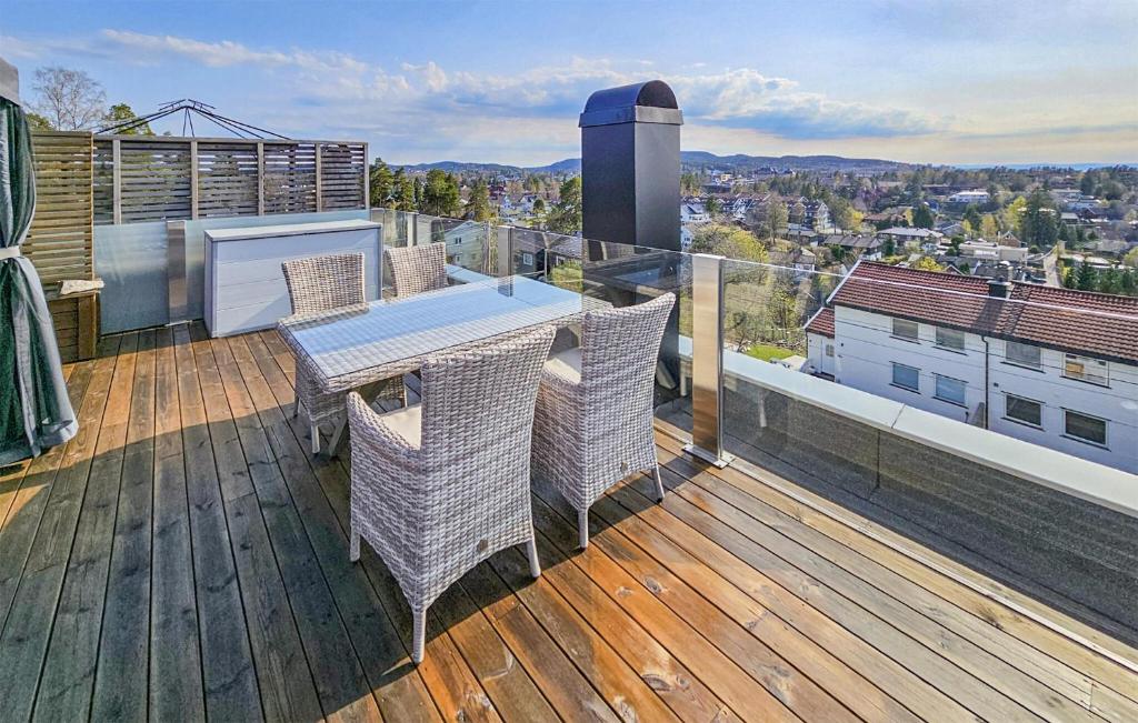 a deck with a table and chairs on a balcony at Lovely Home In Oslo With Kitchen in Oslo