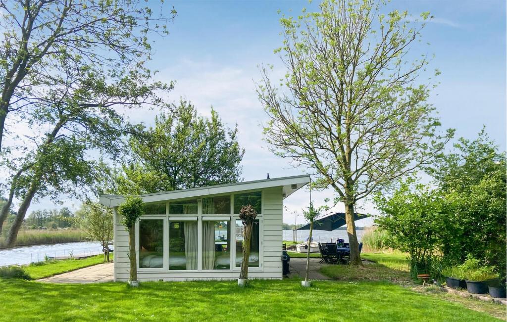 a tiny house on the side of a river at Lakehouse Reeuwijk in Reeuwijk
