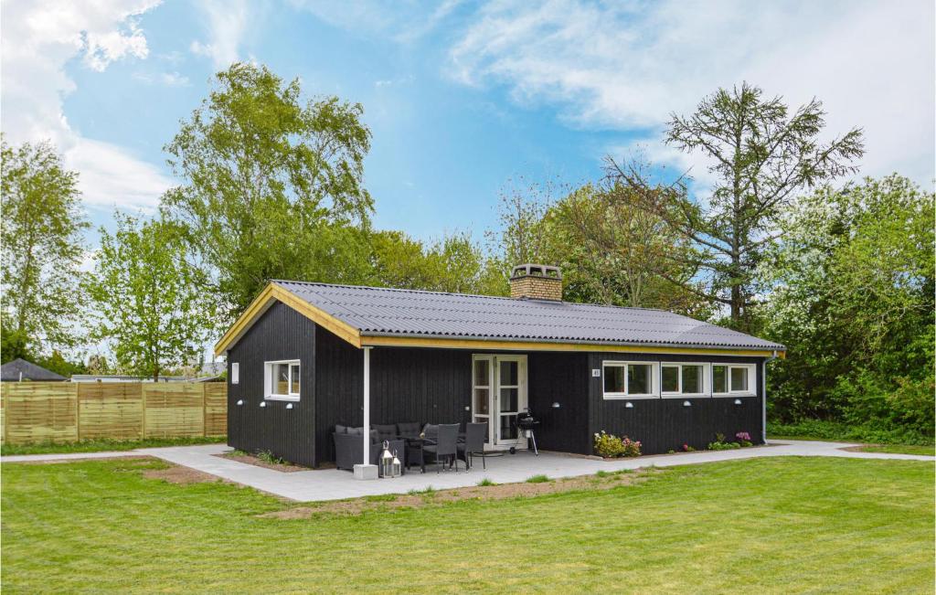 een zwart tiny house met een patio in een tuin bij Amazing Home In Kge With Kitchen in Strøby Egede