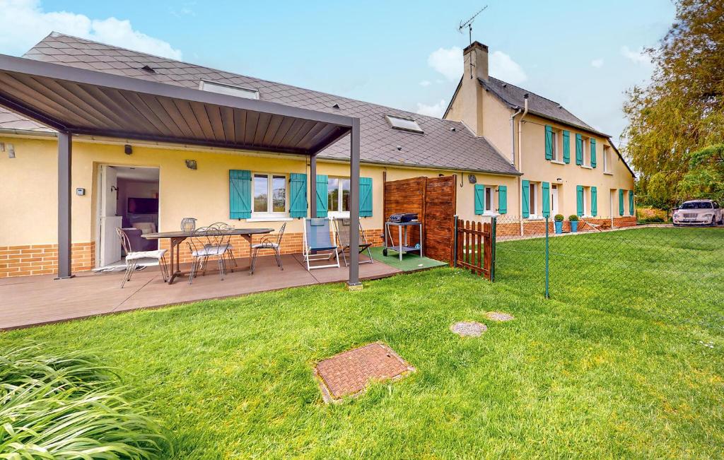 a house with a deck with a table in the yard at 2 Bedroom Lovely Home In Bourville in Sainte-Colombe